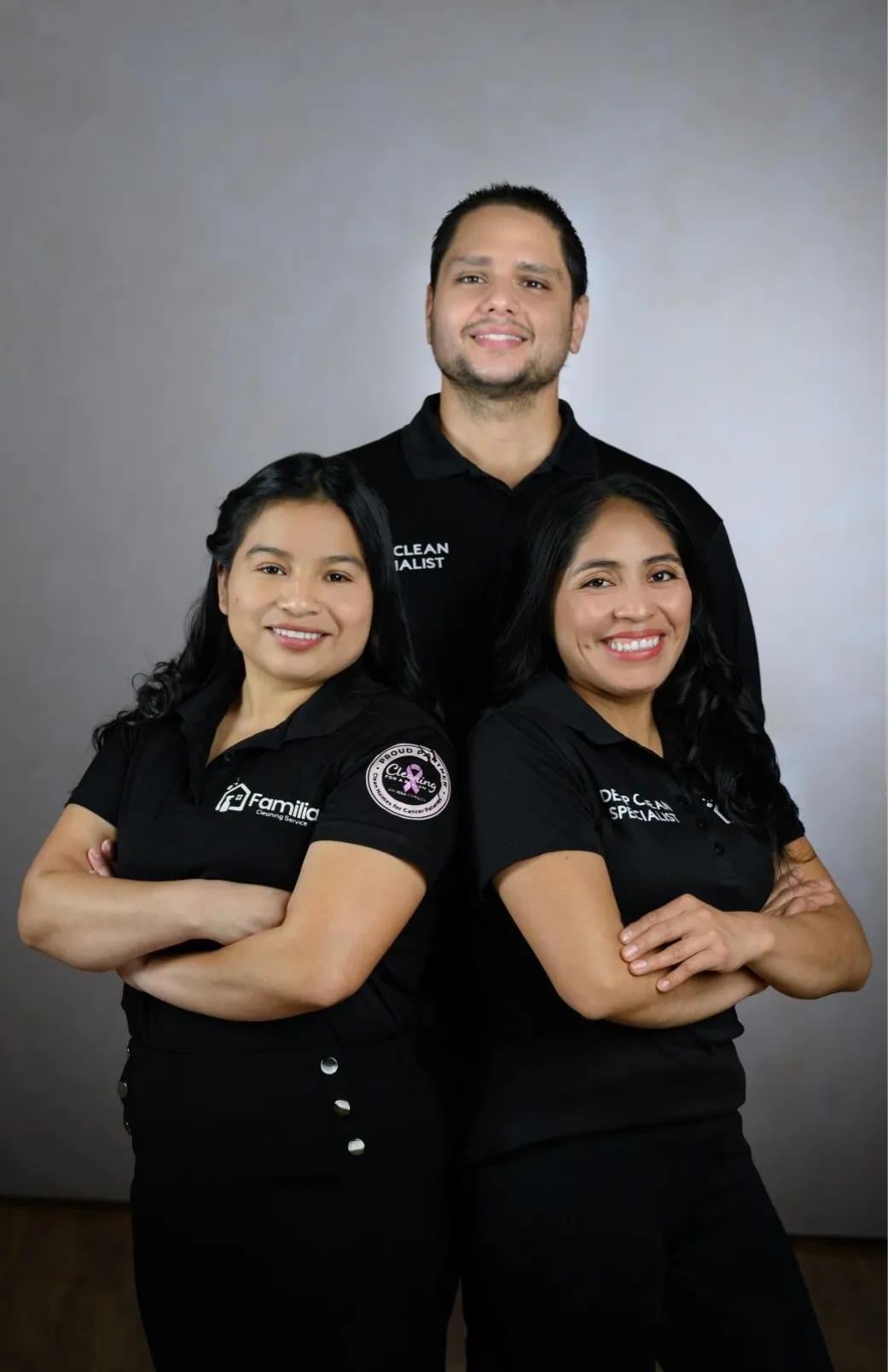 Three smiling professional cleaners from Família Cleaning Services in uniform, representing trusted cleaning services in Connecticut and Massachusetts